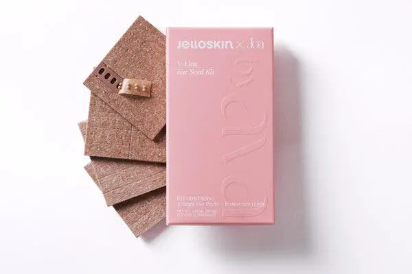 Sheets of neutral-colored strips stacked next to a pink box.