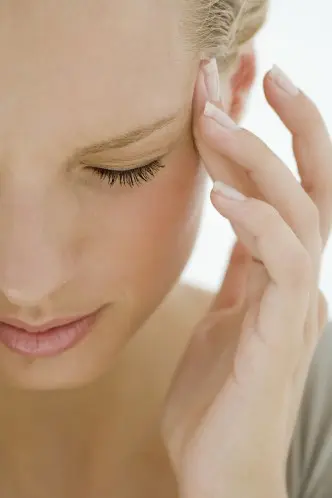 Woman with her hand on her ear, set against a white background